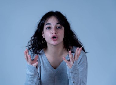 Yüz ifadeleri ve duygular. Kızgın bir yüz çekici genç İspanyol kadın portresi kapatın. Kızgın ve çılgın bağıran ve öfkeli jestler yapma arıyorum. Moody arka plan üzerinde izole.