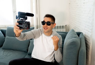 Genç mutlu erkek blogger a video özel öğretmen için internet filme fotoğraf makinesi ekranında portre yaşam tarzı. Bin yıllık kişi, yeni moda ve modern teknoloji, serbest ve yaratıcı iş kavramı.