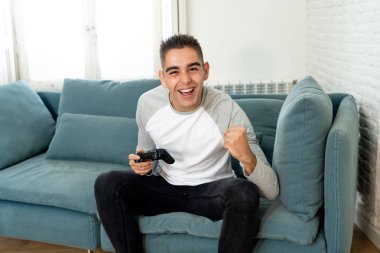 Video having oyunculuk ile konsol oyun İstasyonu ve video erkek oyun bağımlılığı ucube yoğun mutlu yüzüne kablosuz uzaktan joystick kullanarak oyunu kazanma oyunları oynamak genç öğrenci adam portresi.