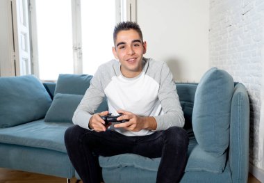 Video having oyunculuk ile konsol oyun İstasyonu ve video erkek oyun bağımlılığı ucube yoğun mutlu yüzüne kablosuz uzaktan joystick kullanarak oyunu kazanma oyunları oynamak genç öğrenci adam portresi.