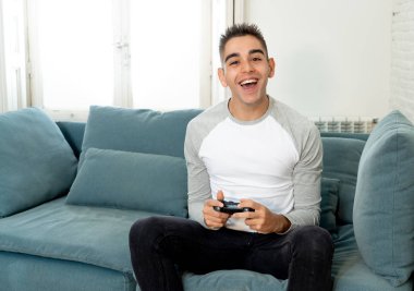 Video having oyunculuk ile konsol oyun İstasyonu ve video erkek oyun bağımlılığı ucube yoğun mutlu yüzüne kablosuz uzaktan joystick kullanarak oyunu kazanma oyunları oynamak genç öğrenci adam portresi.