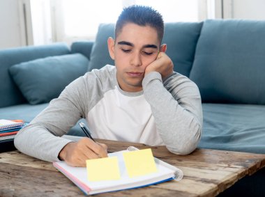 Çalışma ve eğitim yapacak işleri ve yorgun üniversite ya da lise erkek öğrenci sıkılmış ve uykuya düşmemeye çalışırken boğulmuş. Son sınıf sınav, ödev için bir öğrenme eğitim zorluklar kavramı.