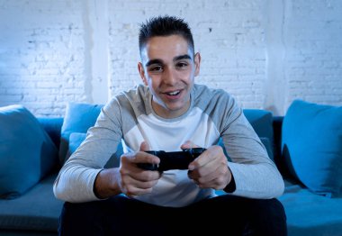 İskambil video spor freak yoğun mutlu yüz ile kablosuz uzaktan joystick kullanarak oyunu kazanma eğleniyor genç öğrenci adam portresi. Konsol erkek oyun bağımlılığı istasyonu ve video oynamak.