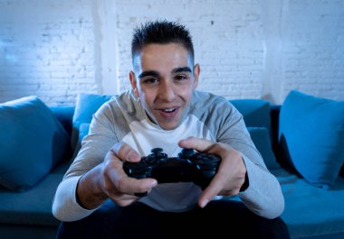 İskambil video spor freak yoğun mutlu yüz ile kablosuz uzaktan joystick kullanarak oyunu kazanma eğleniyor genç öğrenci adam portresi. Konsol erkek oyun bağımlılığı istasyonu ve video oynamak.