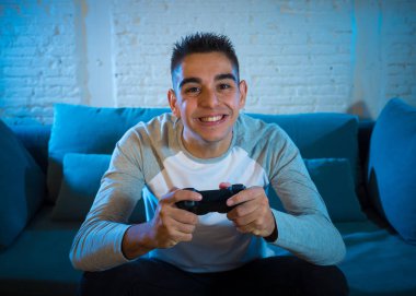 Genç adam eğleniyor portresi kazanan kutluyor ucube yoğun mutlu yüz ile kablosuz uzaktan joystick kullanarak video oyunları oynamak. Konsol erkek oyun bağımlılığı istasyonu ve video oynamak.