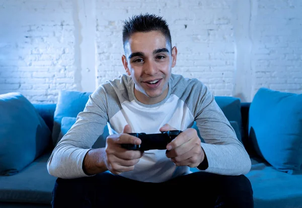 İskambil video spor freak yoğun mutlu yüz ile kablosuz uzaktan joystick kullanarak oyunu kazanma eğleniyor genç öğrenci adam portresi. Konsol erkek oyun bağımlılığı istasyonu ve video oynamak.