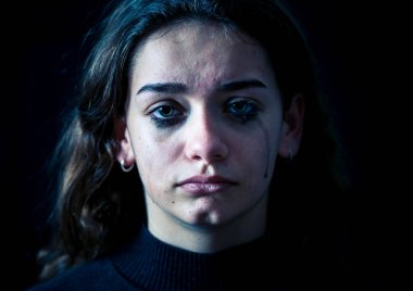 Ağlayan bir okulda, depresif, yalnız, yorgun, stresli genç çocuk kız closeup. Siyah arka plan üzerine izole. İnsan duyguları, çocukluk depresyon, duygusal acı. Zorbalık ve çocuk istismarı kavramı.