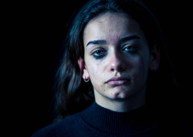 Ağlayan bir okulda, depresif, yalnız, yorgun, stresli genç çocuk kız closeup. Siyah arka plan üzerine izole. İnsan duyguları, çocukluk depresyon, duygusal acı. Zorbalık ve çocuk istismarı kavramı.
