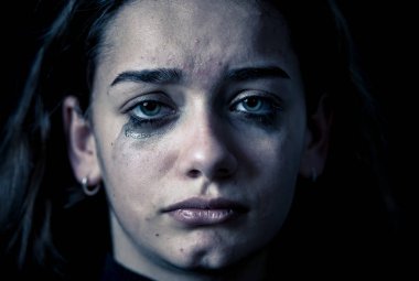 Ağlayan bir okulda, depresif, yalnız, yorgun, stresli genç çocuk kız closeup. Siyah arka plan üzerine izole. İnsan duyguları, çocukluk depresyon, duygusal acı. Zorbalık ve çocuk istismarı kavramı.