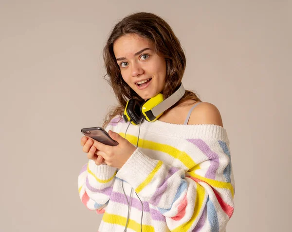 华丽开朗的青少年妇女的肖像听音乐耳机上寻找在线音乐在手机上的中性背景 在积极的情感 休闲和技术的概念 — 图库照片