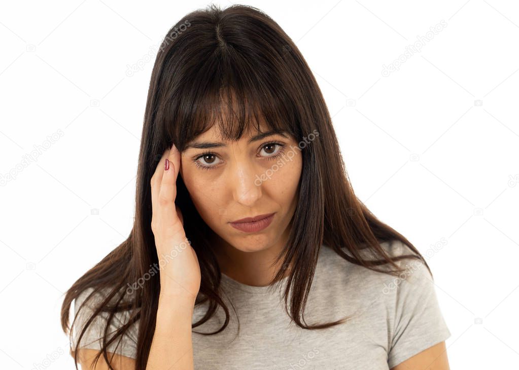 Close up portrait of a young sad woman, serious and concerned, looking worried and thoughtful suffering from migraines. Isolated on white background. In facial expressions and emotions and heath care.