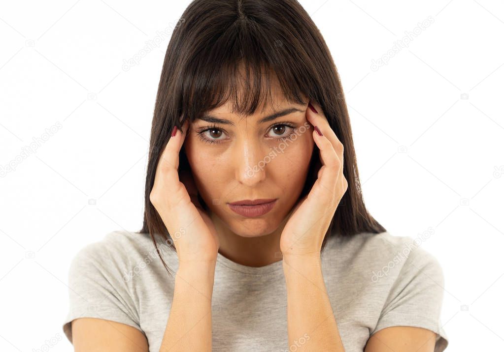 Close up portrait of a young sad woman, serious and concerned, looking worried and thoughtful suffering from migraines. Isolated on white background. In facial expressions and emotions and heath care.