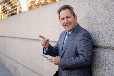 Orta yaşlı yakışıklı işadamı ofiste Kentsel şehir dışında cep telefonu app gönderen iletisinde kullan