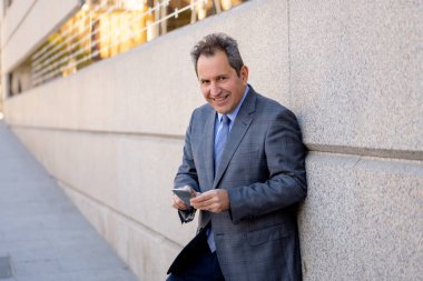 Orta yaşlı yakışıklı işadamı ofiste Kentsel şehir dışında cep telefonu app gönderen iletisinde kullan