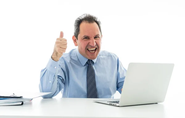 Зрелый кавказский бизнесмен, работающий за ноутбуком в офисе в счастливой работе и удовлетворении — стоковое фото