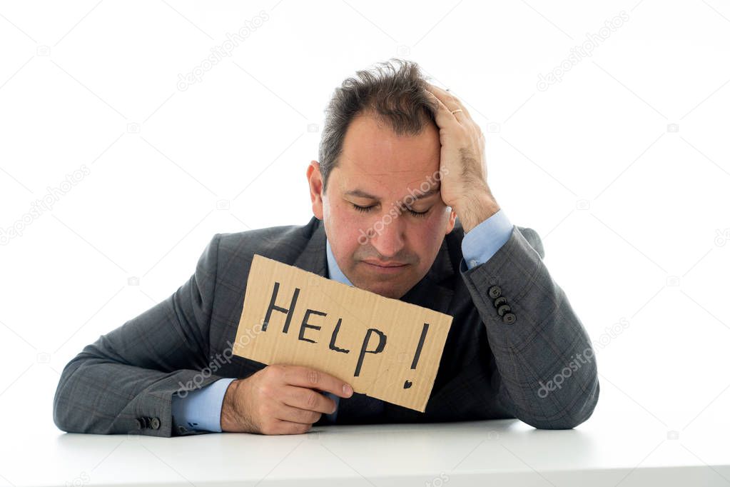Attractive mature businessman overwhelmed and tired holding a help sign