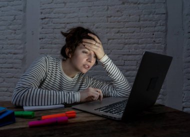 Aşırı çalışmış ve yorgun kadın öğrenci gece geç saatlere kadar çalışan onu laptop uykuya uyumak için değil çalışıyor, endişeli ve üzgün yorgun hissediyorum. Moody koyu ışık. Online öğrenme ve stres iş kavramı.