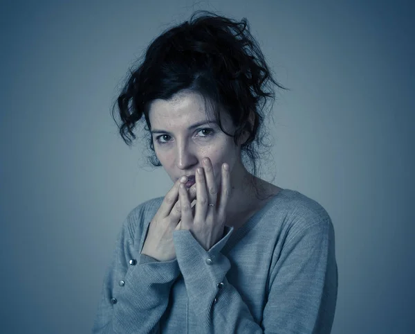 Close up of young scared and frightened woman, covering herself from something scary or intimidating. Feeling fear and anxiety. In facial expressions and emotions concept.