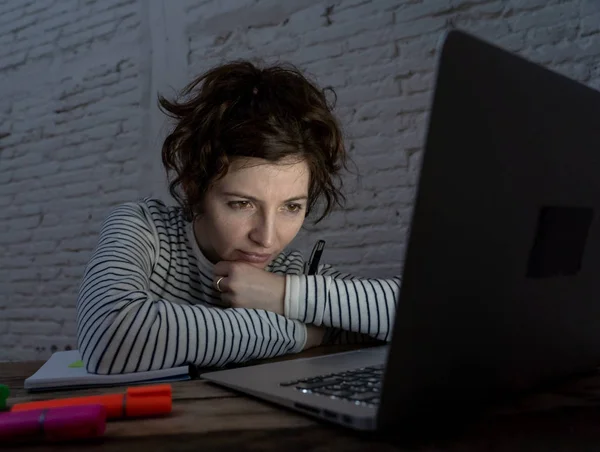 過負荷と疲れた女性の学生は 彼女のラップトップ上で夜遅く働いて 疲れた感じ 心配して悲しくないようにしています ムーディー暗い光 オンライン学習とストレスワークのコンセプト — ストック写真
