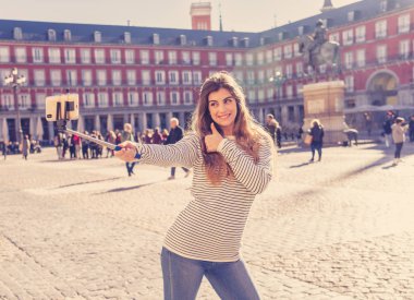 Güzel genç Kafkas kadın mutlu ve heyecanlı Plaza Mayor Madrid kendini bir fotoğraf çekici. Tarihi mimari zevk neşeli arıyorum. Avrupa'da seyahat etmek turizm, Avrupa şehri,.
