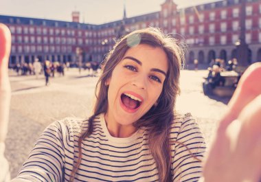 Güzel genç turist öğrenci mutlu ve heyecanlı Plaza Mayor kamerayı ve plaza Mayor Madrid İspanya bir selfie alarak Madrid. Seyahat etmek turizm, Avrupa şehri, Avrupa ve bağlantıları.