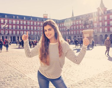 Güzel genç turist kadın mutlu ve heyecanlı Plaza Mayor Madrid İspanya bakarak eğleniyor ve güneşli bir günde işareti Yaşasın yapıyor neşeli. Avrupa ve öğrenci boşluk yıl çevresinde turizm, seyahat.