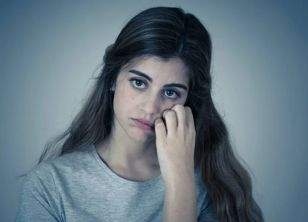 Portrait of young sad woman, serious and concerned crying and feeling worried and depressed isolated on neutral background. In People human expressions broken heart and youth depression.