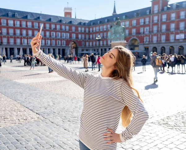 美しい若い白人学生観光女性 Selfie や彼女の観光プラザ マヨール マドリード スペインの世界ブログ ウェブの周りの旅行のための動画を撮影します ソーシャル メディアとヨーロッパの休暇に — ストック写真