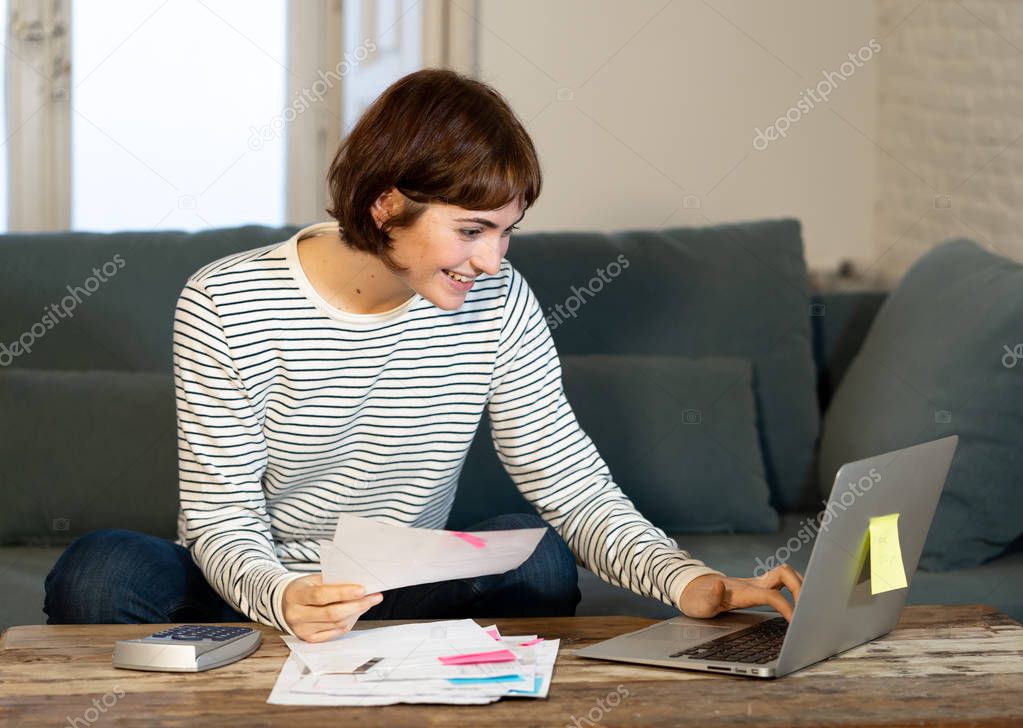 Happy woman with laptop feeling successful accounting home finances calculating costs, charges, mortgage, taxes and paying bills. In e-banking, e-commerce and home or small business accountant.