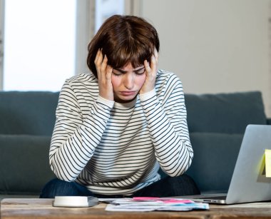 Stres muhasebe ev veya küçük işletme mali çok fazla borç ve giderleri ile genç kadın endişeli ve umutsuz. Online bankacılık, ödeme faturaları ipotek ve mali sorunlar kavramı.