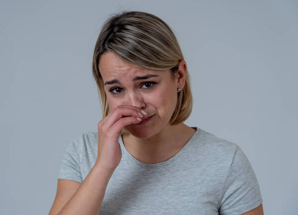 Close up portrait of young sad and anxious woman, crying, looking miserable and hopeless. Feeling sorrow, grief and fear. Studio shot copy space. In People facial expressions and emotions concept.