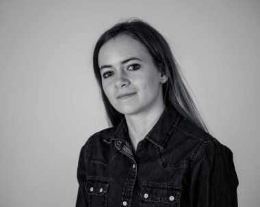 Siyah ve beyaz stüdyo portre küçük genç güzel genç sarı saç giyen Jean gömlek duygu emin, rahat poz ve modelleme. Gençlik, yaşam tarzı ve güzellik konsepti.