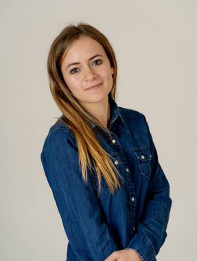 Küçük güzel genç kadının stüdyo portresi, sarı saçlı, kendine güvenen, rahat poz veren ve modelleme yapan Jean shirt giyiyor. Nötr arka planda izole. Yaşam tarzı ve güzellik konsepti.