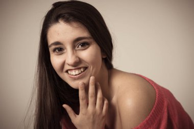 Mutlu yüz, güzel gülümseme ile genç güzel esmer kadının portre yakın. Rahat giysiler giyip kameraya bakıyor. Kadınlarda doğal güzellik, modelleme ve yaşam tarzı kavramı.