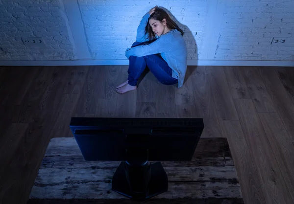 被恐吓的沮丧年轻妇女在地面上盯着电脑遭受骚扰和网络欺凌的戏剧性画像 在网上被跟踪者虐待 感到绝望 互联网上的危险 — 图库照片