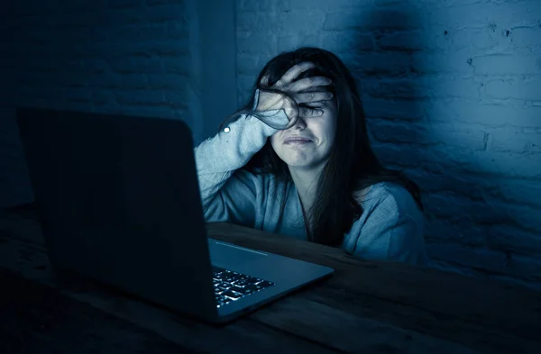 悲しい恐怖の若い女性の劇的な肖像を強調し サイバーいじめや嫌がらせを苦しんでノートパソコンを見つめて心配 ストーカーによるオンライン虐待と脅迫の犠牲者 インターネットの危険性に — ストック写真