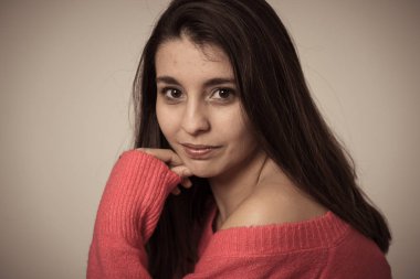 Mutlu yüz, güzel gülümseme ile genç güzel esmer kadının portre yakın. Rahat giysiler giyip kameraya bakıyor. Kadınlarda doğal güzellik, modelleme ve yaşam tarzı kavramı.