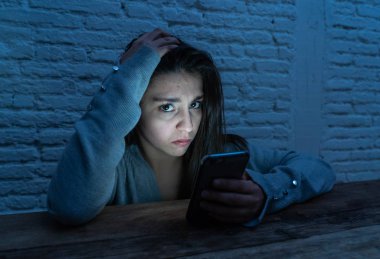 Üzücü korkmuş genç kadın çevrimiçi taciz ve siber zorbalık kurbanı dramatik portresi. akıllı cep telefonu bakarak vurguladı ve korku online Stalker tarafından istismar olmak. İnternet tehlikeleri.