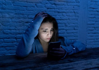 Üzücü korkmuş genç kadın çevrimiçi taciz ve siber zorbalık kurbanı dramatik portresi. akıllı cep telefonu bakarak vurguladı ve korku online Stalker tarafından istismar olmak. İnternet tehlikeleri.