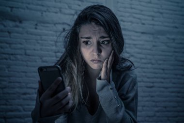 Siber zorbalık ve taciz acı akıllı cep telefonu üzücü korkmuş genç kadının dramatik portresi. Yalnız, depresif ve korku online Stalker tarafından istismar olma hissi. İnternet tehlikeleri.