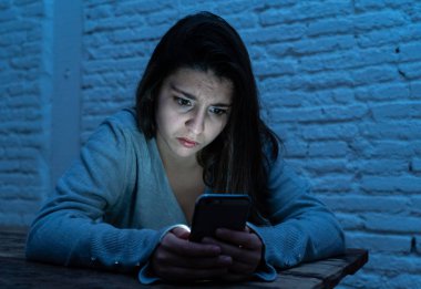 Siber zorbalık ve taciz acı akıllı cep telefonu üzücü korkmuş genç kadının dramatik portresi. Yalnız, depresif ve korku online Stalker tarafından istismar olma hissi. İnternet tehlikeleri.