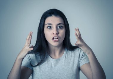 Öfkeli yüz ile stres genç çekici sinirli Latin kadın yakın. Kızgın ve öfkeli jestler yaparak hayal kırıklığına bakıyordu. Nötr arka planda. İnsan yüz ifadeleri ve duygular.