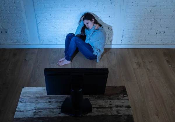被恐吓的沮丧年轻妇女在地面上盯着电脑遭受骚扰和网络欺凌的戏剧性画像 在网上被跟踪者虐待 感到绝望 互联网上的危险 — 图库照片