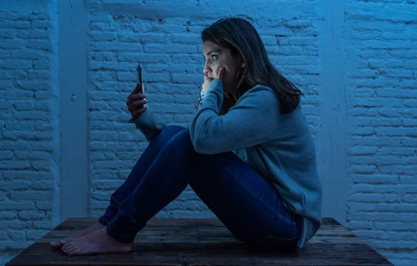 夜の床の上に悲しい怖がった若い女性の肖像は サイバーいじめの嫌がらせに苦しむスマート携帯電話を強調し 心配しています ストーカーによってオンライン虐待されることによって必死と落ち込んで — ストック写真