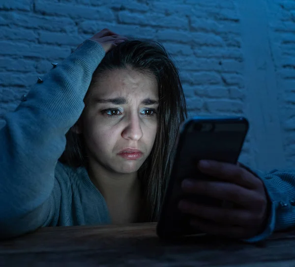 Üzücü korkmuş genç kadın çevrimiçi taciz ve siber zorbalık kurbanı dramatik portresi. akıllı cep telefonu bakarak vurguladı ve korku online Stalker tarafından istismar olmak. İnternet tehlikeleri.