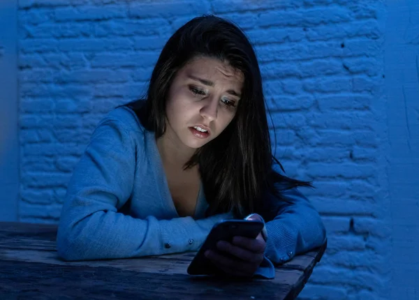 Siber zorbalık ve taciz acı akıllı cep telefonu üzücü korkmuş genç kadının dramatik portresi. Yalnız, depresif ve korku online Stalker tarafından istismar olma hissi. İnternet tehlikeleri.
