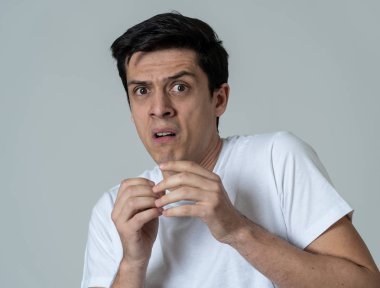 Genç adam korkuyor ve korku, anksiyete jestleri yapma şok hissediyor. Korkmuş ve çaresiz görünümlü kendini örtbas etmeye çalışıyor. Kopya alanı ile portre. İnsanlar ve ınsan ifadeleri ve duygular.