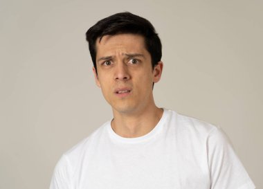 Genç adam korkuyor ve korku, anksiyete jestleri yapma şok hissediyor. Korkmuş ve çaresiz görünümlü kendini örtbas etmeye çalışıyor. Kopya alanı ile portre. İnsanlar ve ınsan ifadeleri ve duygular.