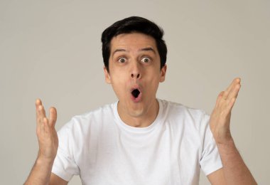 Piyango kazanan veya sürpriz ve mutlu yüz ve jestleri ile büyük başarı sahip genç şok adam portre. Insanlar, yüz Ifadesi, Insan duygular ve kutlama. Stüdyo çekimi.