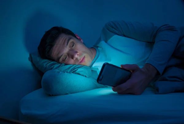 침대에서 스마트 인터넷 스러운 빛으로 어두운 방에서 불면과 불면증과 모바일 — 스톡 사진